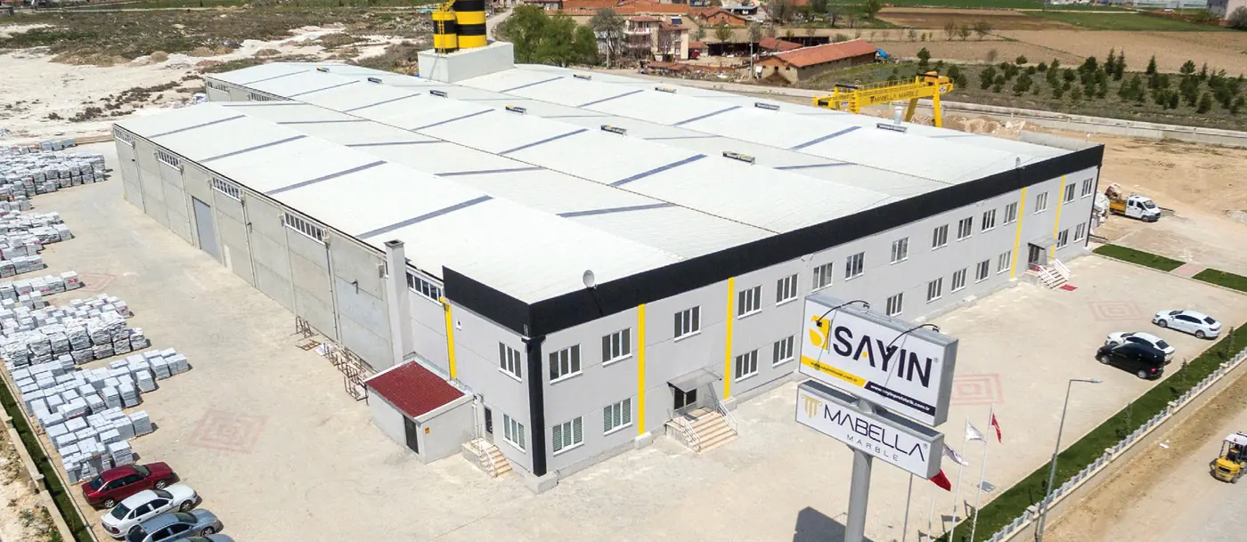 Sayın üretim tesisi — çatı ve cephe kaplamalarıyla havadan görünüm